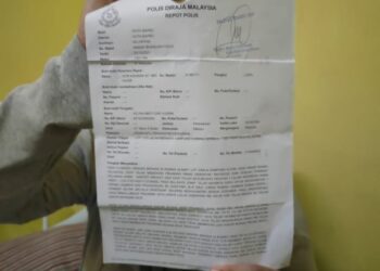SEORANG mangsa ugutan ah long menunjukkan salinan laporan polis dibuat kerana bimbang keselamatan diri dan keluarganya di kampung di Kota Bharu, semalam. - UTUSAN/ROHANA MOHD. NAWI