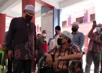 AHMAD Yakob beramah mesra dengan penerima vaksin semasa lawatan di Program Outreach Vaksinasi DUN Pasir Pekan di SK Kampung Laut, Tumpat, Kelantan, hari ini. - FOTO/YATIMIN ABDULLAH