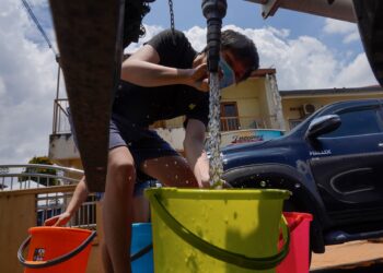 PENDUDUK di Taman Bukit Serdang, Seri Kembangan mengambil bekalan air yang disediakan oleh petugas Air Selangor ketika tinjauan Taman Bukit Serdang, Seri Kembangan semasa gangguan bekalan air di beberapa wilayah di negeri Selangor hari ini. - UTUSAN/AMIR KHALID