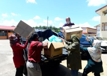 REENA AWLIYATUL IMANI Reezal Merican (atas pacuan empat roda) dan Ismalina Ismail (bawah, kiri) mengangkat kotak tuala wanita yang disumbangkan di Sekolah Menengah Kebangsaan (SMK) Lepar Hilir di Kuantan, Pahang. – UTUSAN/SHAIKH AHMAD RAZIF