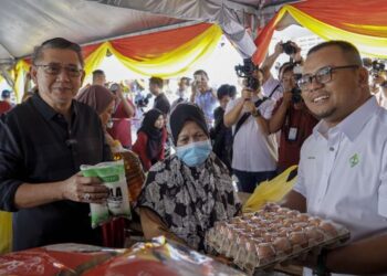 AMIRUDIN Shari (kanan) bersama Salahuddin Ayub (dua, kiri) beramah mesra bersama pengunjung yang membeli barangan di Tapak Jualan Mega Ehsan Rahmah (JER) selepas majlis pelancaran di Dewan Serbaguna Majlis Perbandaran Ampang Jaya (MPAJ), Ampang, Selangor, hari ini. - UTUSAN/FARIZ RUSADIO