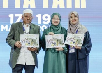 MD. DAUD Che Ngah (kiri ) dan Ida Riswana Idris (kanan) bersama Ikon Andalusia yang juga juara Tilawah al-Quran peringkat Antarabangsa, Farhatul Fairuzah menunjukkan brosur dan pakej umrah Andalusia Travel & Tours Sdn. Bhd. di Matta Fair 2023 di MITEC, Kuala Lumpur, semalam. – MINGGUAN/FARIZ RUSADIO