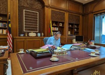 ANWAR Ibrahim menyemak beberapa dokumen dan surat di pejabatnya di Bangunan Perdana Putra, Putrajaya. - FB ANWAR IBRAHIM