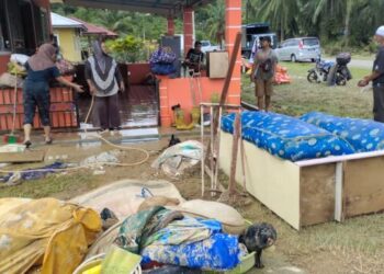 SEBAHAGIAN anggota Kor-SISPA USIM membantu membersihkan rumah salah seorang penduduk yang dilanda banjir di Kampung Sungai Timun, Rembau, Negeri Sembilan, hari ini. – FOTO/NOR AINNA HAMZAH