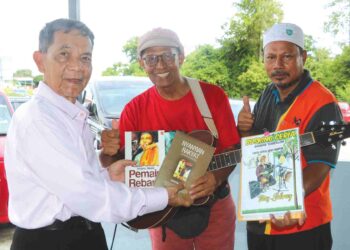 ARIPIN ( kiri) menyampaikan buku-buku karangannya kepada Mas Sabray ( tengah) di Restoran Ikan Patin Along, Temerloh baru-baru ini. 
– UTUSAN/ SALEHUDIN MAT RASAD