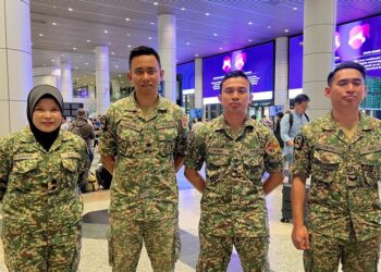 ZURAINI Sulaiman dan Dr. Mohd. Khairul Anuar Kamarudin (dua kiri) bersama pegawai bertugas di Hospital Medan Malaysia selamat pulang ke tanah air di KLIA Terminal 1, Sepang Selangor. - UTUSAN/KAMARIAH KHALIDI