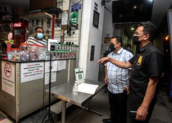 AZMAN Adam (kanan) memeriksa buku daftar masuk pengunjung semasa menyertai Operasi Samar A342 di premis makanan sekitar Ayer 8, Presint 8 di Putrajaya. -UTUSAN/FAISOL MUSTAFA