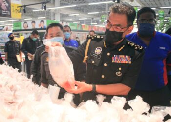 AZMAN ADAM memeriksa harga ayam yang dijual di sebuah pasar raya di Georgetown, Pulau Pinang dalam tinjauan susulan aduan kenaikan harga barangan itu dalam kalangan pengguna.- UTUSAN/MUHAMAD FIRDAUS AMRAN