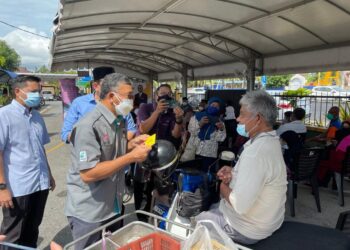 AZLAN MAN (tengah) pada program agihan 1,000 bakul makanan peringkat negeri ini di Masjid Tun Abdul Razak, Repoh, Kangar, Perlis, hari ini. - UTUSAN/NAZLINA NADZARI