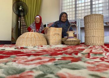 CHE Zainah Che Ibrahim (kanan) dan kakaknya, Che Manai bersama barangan kraf tangan yang dijual di kedai mereka di Jalan Pauh, Arau, Perlis, semalam. – UTUSAN/MOHD. HAFIZ ABD. MUTALIB