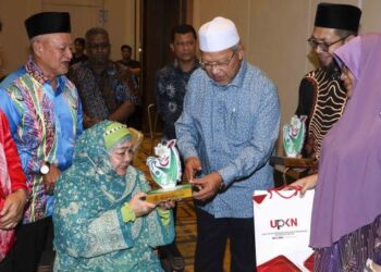 AHMAD Yakob menyampaikan sumbangan kepada artis veteran, Mek Habsah pada Majlis Malam Selebriti dan Anak Seni Bersama Pimpinan Kerajaan Negeri Kelantan di Putrajaya. - FOTO/FAISOL MUSTAFA