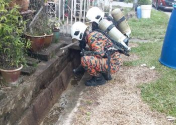 ANGGOTA Hazmat menjalankan kerja-kerja meneutralkan bahan kimia Sodium Chlorite yang dibuang ke dalam longkang di kawasan rumah murah Kampung Fikri, Kemaman, Terengganu semalam. - IHSAN BOMBA