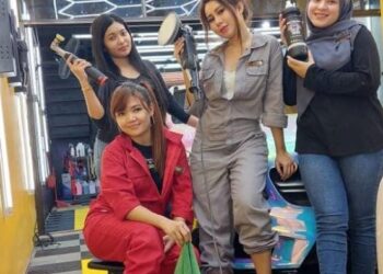 ALIA Fasha Jalani (kiri, baju merah) bersama rakannya yang bersama-sama mengusahakan pusat cucian kereta, Detailmode Carwash berhampiran Plaza Tol Kuantan di Kuantan, Pahang.