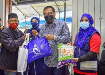 RAMLI Mohd. Noor (tengah) bersama Tuan Noraizan Tuan Long (kanan) menyampaikan sumbangan barang keperluan dapur kepada seorang penduduk sempena Program Ziarah Komuniti AmanahRaya Berkat Ramadan di Tanah Rata di Cameron Highlands, Pahang. - FOTO/HARIS FADILAH AHMAD