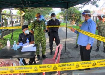 AMINUDDIN Harun beramah mesra dengan anggota keselamatan yang bertugas di PKTK PKPD di Taman Chembong Utama, Rembau, Negeri Sembilan  hari ini. - FOTO/MUHAMMAD IZZAT TERMIZIE