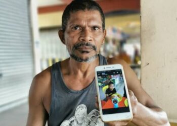 BAHARUDIN Abdul Rahman menunjukkan gambar anaknya, Muhammad Haikal Baharudin, 12, yang hilang sejak awal pagi Isnin lalu ketika ditemui Utusan Malaysia di Medan Selera Taman Seri Mawar, Senawang, Seremban hari ini. - FOTO/AFIFI HAFIZ MOHD. NOR