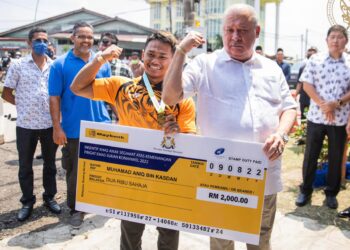 SULTAN Ibrahim menyampaikan cek kepada Mohd. Aniq Kasdan di Kampung Paya Merah di Labis, Segamat semalam.