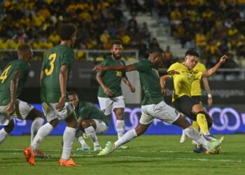 ARIF Aiman Hanapi (kanan) diasak pemain Kepulauan Solomon dalam aksi persahabatan di Stadium Sultan Mizan Zainal Abidin, Gong Badak, Rabu lalu. - UTUSAN/PUQTRA HAIRRY