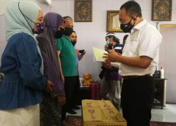 AWANG Hashim (kanan) ketika menziarahi Azrolhisham Abdullah (tiga dari kiri) dan ibunya, Aishah Yahya di Felda Seberang Tayor di Kemaman, semalam. - FOTO/NIK NUR IZZATUL HAZWANI NIK ADNAN
