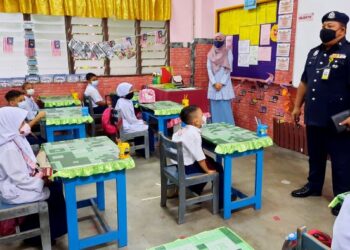 AZHAR Hashim memberi penerangan mengenai SOP kepada pelajar tahun satu di SK Air Merah, Kulim, Kedah hari ini. - FOTO/AZAHAR HASHIM