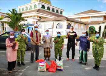 IKHTIMAN Ismail (tiga dari kiri) bersama petugas barisan hadapan dan asnaf ketika menyampaikan barang keperluan dapur dan wang tunai di perkarangan Masjid Tengku Mahkota Abdullah, Jerantut, Pahang baru-baru ini. – UTUSAN/HARIS FADILAH AHMAD