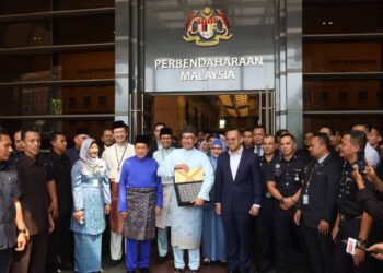  ANWAR Ibrahim menunjukkan beg berisi dokumen sebelum menuju ke Parlimen bagi pembentangan Belanjawan 2023.  - UTUSAN/FAISOL MUSTAFA