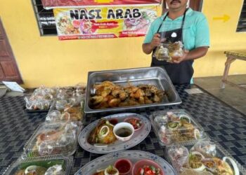 SAHARUDIN Ibrahim kini berniaga nasi Arab untuk menarik pelanggan ke kedai miliknya, Mazni Ikan Bakar di Tok Bali, Pasir Puteh, Kelantan. - UTUSAN/TOREK SULONG