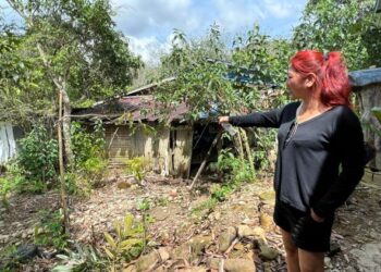 CHONG Yok Fon menunjukkan rumah penduduk yang sering terjejas dengan banjir kilat di Kampung Batu Papan 2, Gua Musang, Kelantan.-UTUSAN/AIMUNI TUAN LAH.