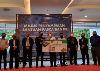 IZHAM Hashim (tengah) menyerahkan bantuan pasca banjir kepada kakitangan jabatan dan agensi di bawah Jawatankuasa Infrastruktur dan Kemudahan Awam di Bangunan SUK di Shah Alam, Selangor, hari ini.