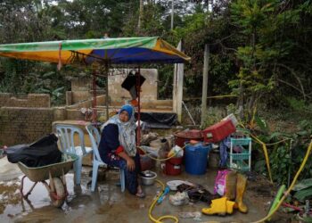 KELIHATAN seorang penduduk Kampung Sungai Lui bersama  peralatan rumah yang terkena banjir di Kampung Sungai Lui di. – UTUSAN/AMIR KHALID