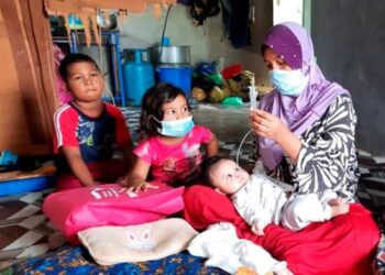 NOR Hasliza Hashim memberi susu kepada Muhammad Haziq Nazmi Anorazmi menggunakan tiub di Kampung Keda Wang, Kubang Pasu, Kedah, semalam.