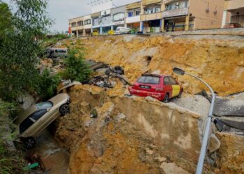 EMPAT daripada lima kenderaan awam yang rosak akibat dalam kejadian tanah mendap dan runtuhan berhampiran longkang  petang semalam di deretan kedai Jalan LP 1A/2 Lestari Perdana, Seri Kembangan, Selangor. -UTUSAN/FARIZ RUSADIO