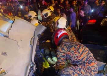 ANGGOTA bomba dan penyelamat mengeluarkan mangsa kemalangan yang tersepit di Kilometer 12, Jalan Batu Pahat-Kluang, malam tadi.