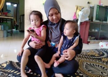 NOR Ainun Mikhayla (kanan) yang menghidap jantung berlubang diriba ibunya semasa ditemui di rumahnya di Taman Sri Binjai, Batu 11, Ketereh, Kota Bharu, Kelantan hari ini. -UTUSAN/ROHANA MOHD. NAWI