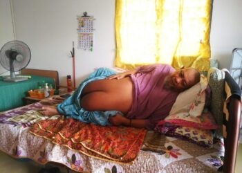 AHMAD Shahrul Nizam Nayan hanya mampu duduk di atas katil ekoran perutnya yang semakin membesar akibat dipenuhi air di rumahnya di Kampung Telok Gong di Klang, Selangor. - UTUSAN/ ABDUL RAZAK IDRIS