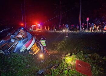 KEADAAN bas ekspres dua tingkat yang terbabas masuk ke dalam parit di Jalan Kuala Sungai Manik, Teluk Intan. - UTUSAN/IHSAN JBPM