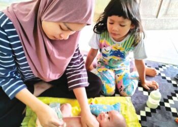ZAKIRAH Ghazali membersihkan badan Muhammad Fayyadh di Kampung Changkat Setol, Changlun, Kubang Pasu, Kedah. - MINGGUAN/MOHD. RAFIE AZIMI