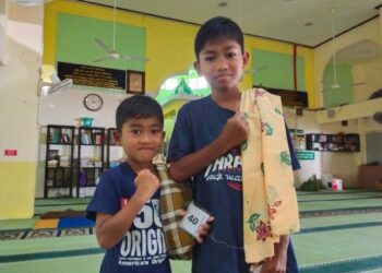 MOHD. Farhan Irshad Mohd. Azim (kiri) bersama abangnya tenang menunggu giliran untuk dikhatankan dalam Program Sunaton Amal Masjid Al-Mustaqim Alor Pasir 2020 bersama gabungan pertubuhan bukan kerajaan di Tanah Merah, Kelantan hari ini. -UTUSAN/YATIMIN ABDULLAH