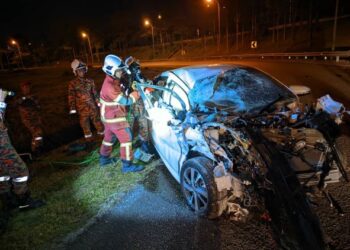 ANGGOTA bomba dan penyelamat mengeluarkan wanita yang tersepit selepas keretanya bertembung dengan lori di Jalan Simpang Renggam - Renggam, Kluang, malam tadi.