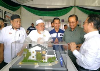 DR. Ahmad Samsuri (dua dari kanan) diberi penerangan mengenai projek perumahan mampu milik dan bercampur yang dibina di Teluk Kalong, Kemaman, Terengganu, semalam. - UTUSAN/NIK NUR IZZATUL HAZWANI NIK ADNAN
