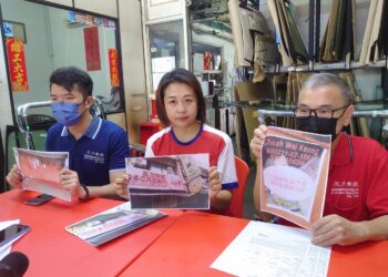 TAY POI KIANG (kanan) menunjukkan poster yang ditampal ah long di hadapan premis memasang cermin kenderaan di Taman Johor Jaya, Johor. 
