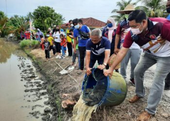 OTHMAN Aziz (depan, kiri) melepaskan ikan di dalam sawah ketika merasmikan Program Jom Turun Bendang di Kampung Pida 8 Tebengau, Ayer Hitam, Jerlun, Kedah. - UTUSAN/MOHD. RIFAAT ABD. HAMID