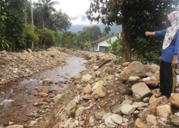 SEORANG penduduk menunjukkan batu yang dijadikan benteng sementara berdekatan rumahnya  selepas kerja-kerja membersih dan mendalamkan sungai di Kampung Acheh, Yan hari ini.