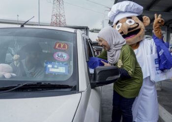 ROZITA Ahmad menyerahkan cenderamata kepada pemandu sempena program kempen Tak Nak Bazir Bernas di LRT Glenmarie, Shah Alam, hari ini. - FOTO/FARIZ RUSADIO