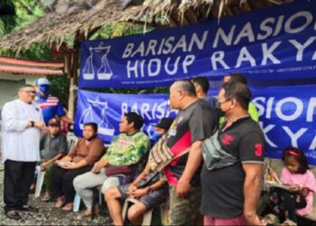 ANUAR Basiran (berdiri dua dari kiri) beramah mesra dengan penduduk Kampung Orang Asli Bukit Tadom, Sepang, Selangor semalam. - UTUSAN/AMREE AHMAD