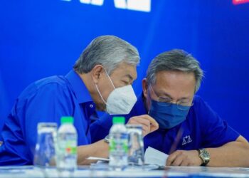 PENGERUSI Barisan Nasional, Datuk Seri Dr. Ahmad Zahid Hamidi (kiri) memperkatakan sesuatu kepada Hasni Mohammad dalam majlis pengumuman calon di Johor Bahru, baru-baru ini. – UTUSAN/FARIZ RUSADIO