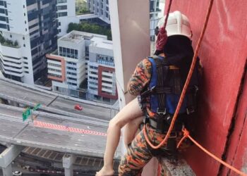 PASUKAN bomba berusaha membawa naik mayat wanita yang tersangkut pada belebas tiang tingkat 20 sebuah kondominium di Petaling Jaya.