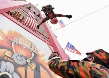 ANGGOTA JBPM Pulau Pinang mengibarkan Jalur Gemilang sambil melakukan aksi lasak pada Program Sambutan Hari Malaysia JBPM Pulau Pinang di Balai Bomba dan Penyelamat, Jalan Perak, Georgetown, Pulau Pinang.