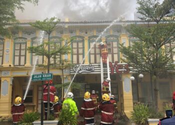 ANGGOTA bomba memadamkan kebakaran melibatkan dua buah premis di Jalan Kerian, Georgetown, Pulau Pinang, hari ini.