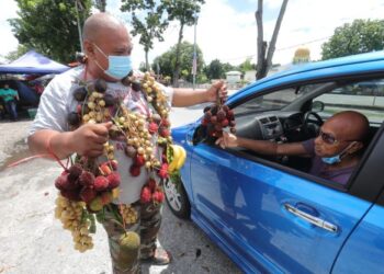 PENIAGA buah Ahmad Izan Latip menggunakan kreativiti tersendiri untuk mempromosikan buah tempatan bermusim di gerai jualannya di hadapan Masjid Daerah Barat Daya, Balik Pulau, Pulau Pinang.